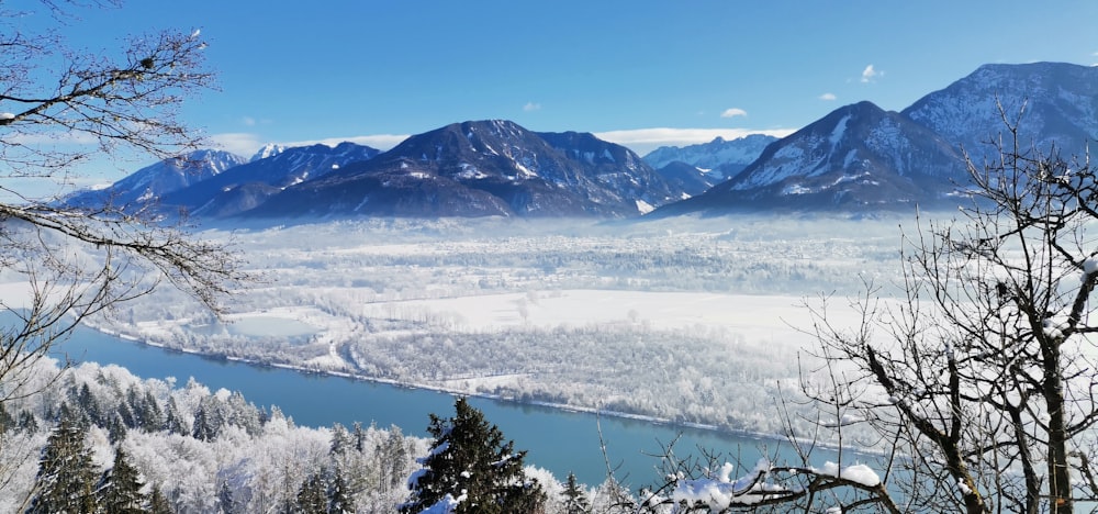 a scenic view of a river surrounded by snow covered mountains