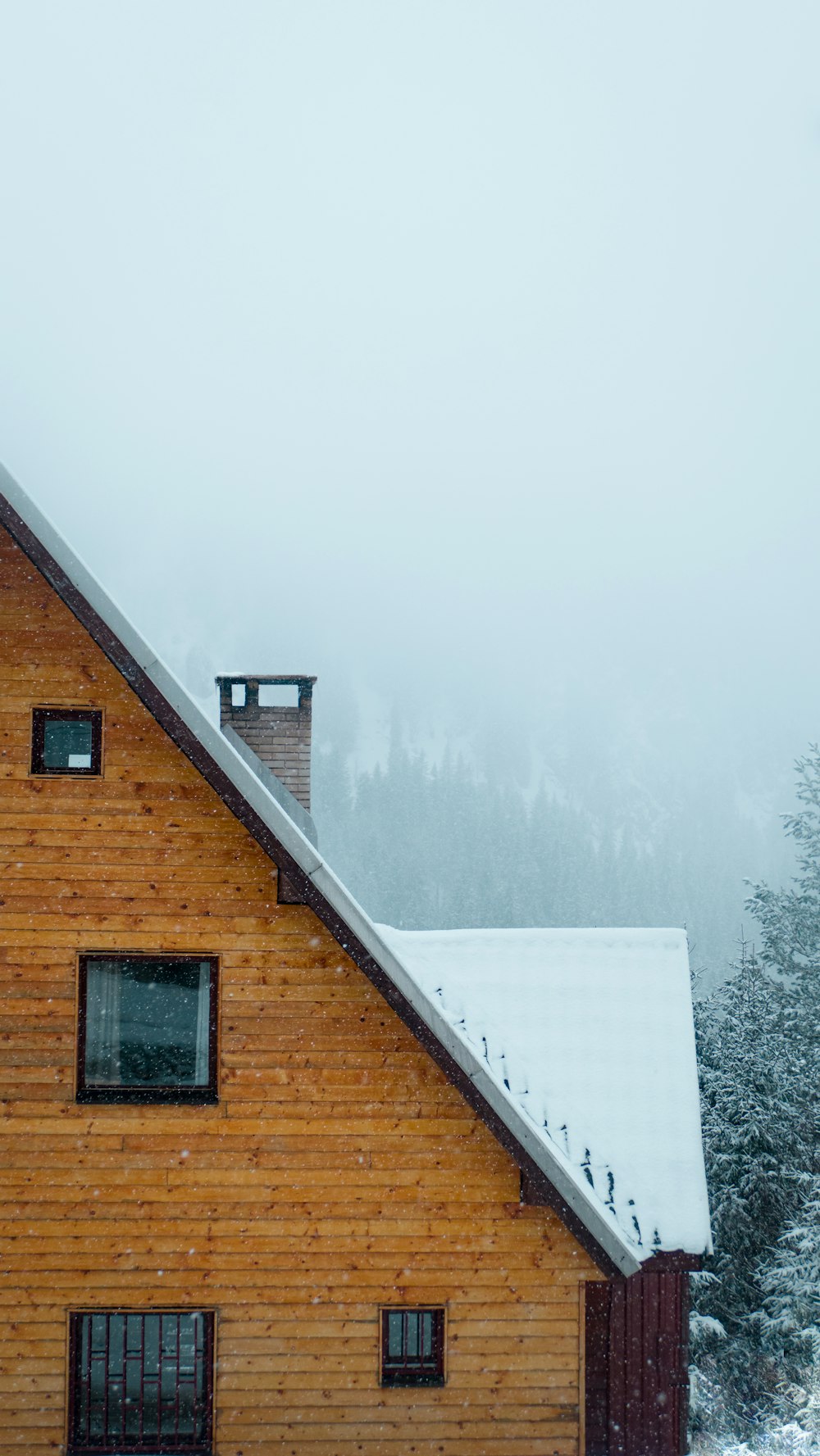 a wooden house with a snow covered roof