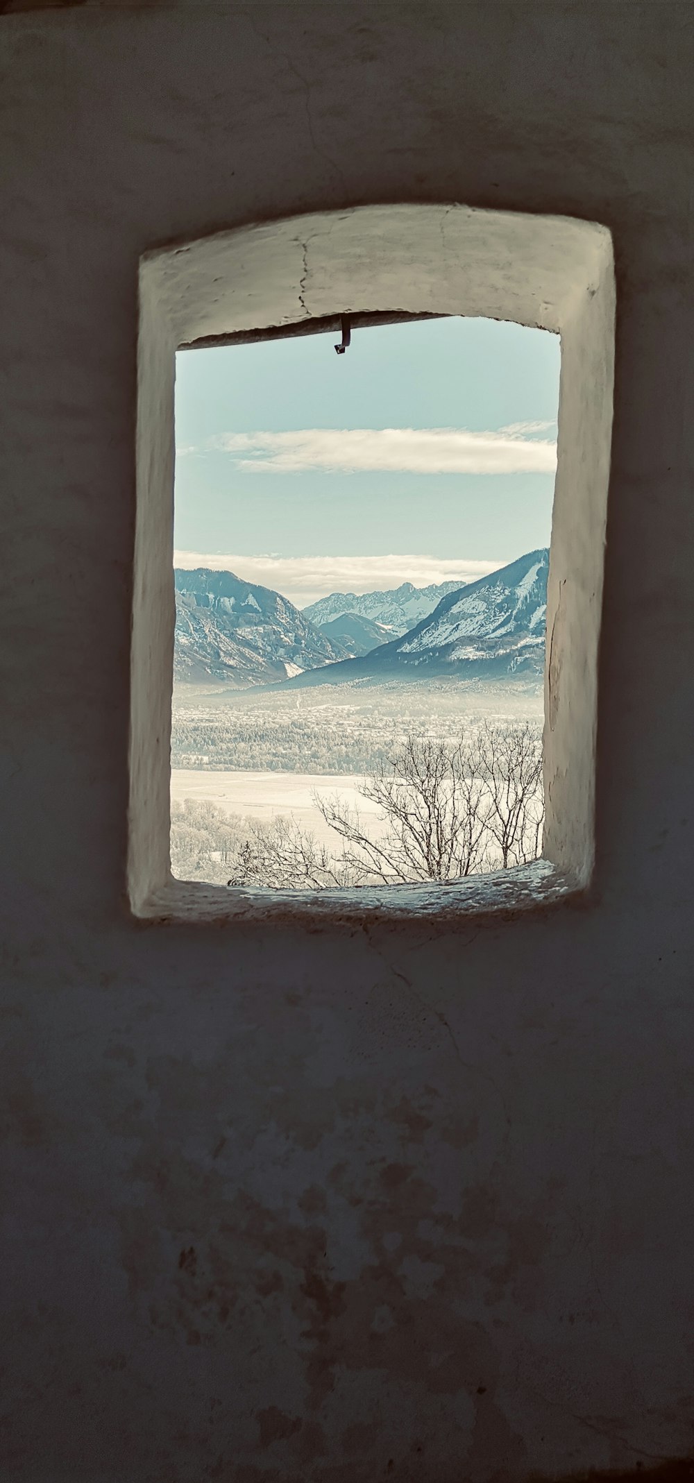 a window with a view of a mountain range
