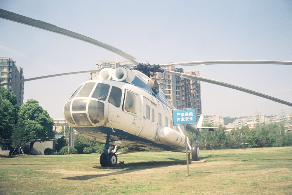 a helicopter parked on the grass in front of a building