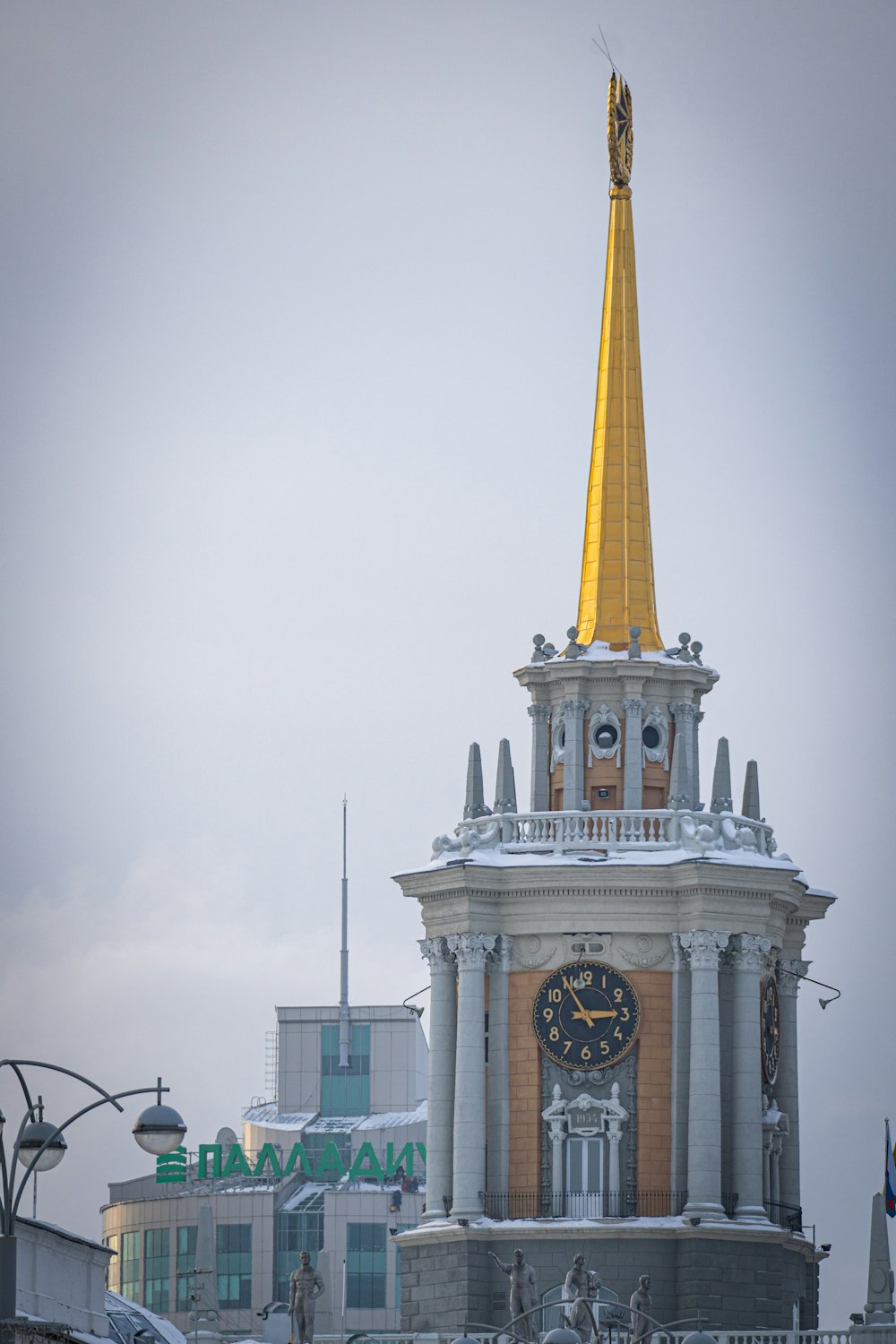 una torre dell'orologio con una guglia d'oro in cima