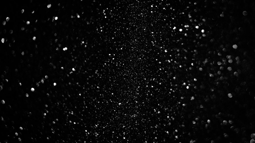 a black and white photo of snow falling