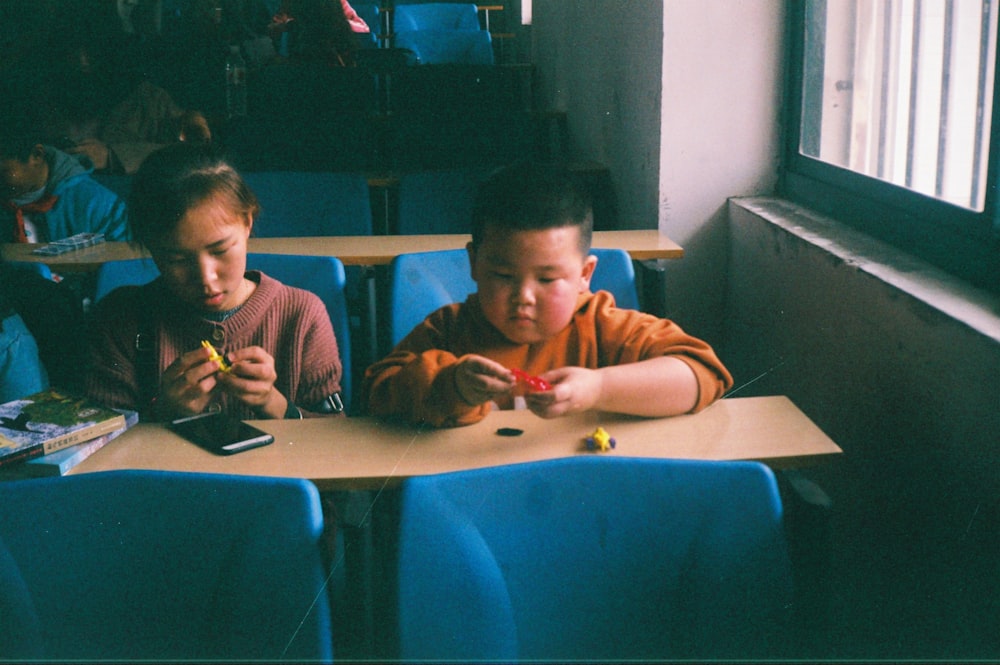 a couple of kids sitting at a table