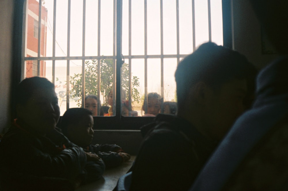 a group of people sitting at a table in front of a window