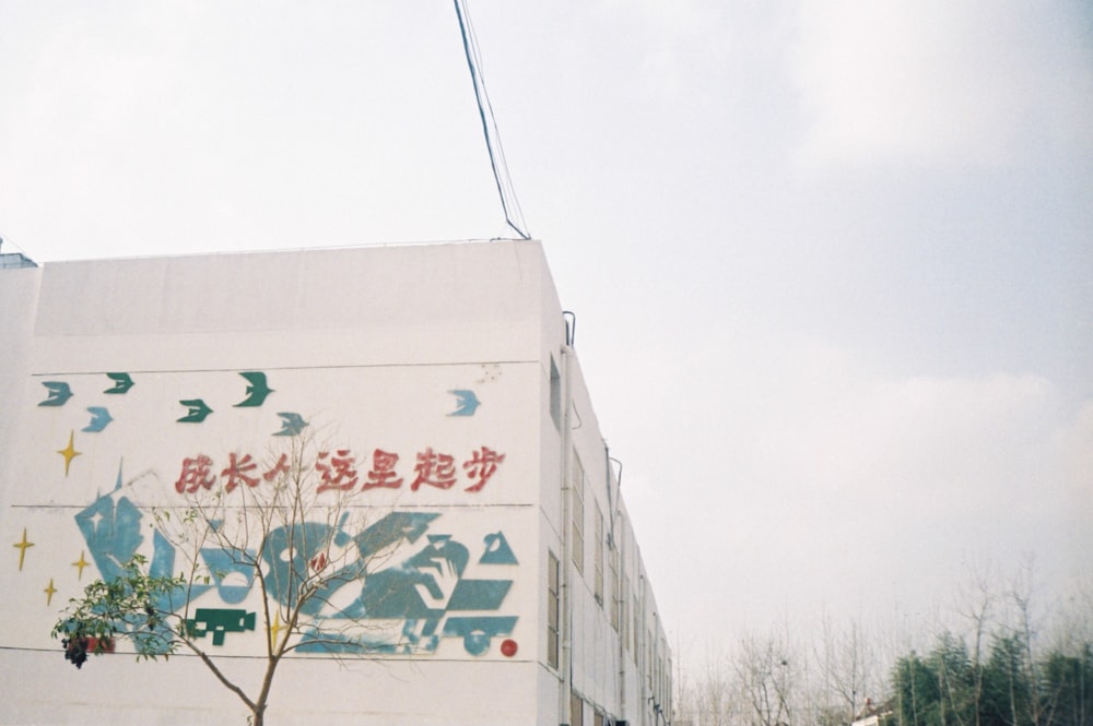 a tree in front of a building with chinese writing on it