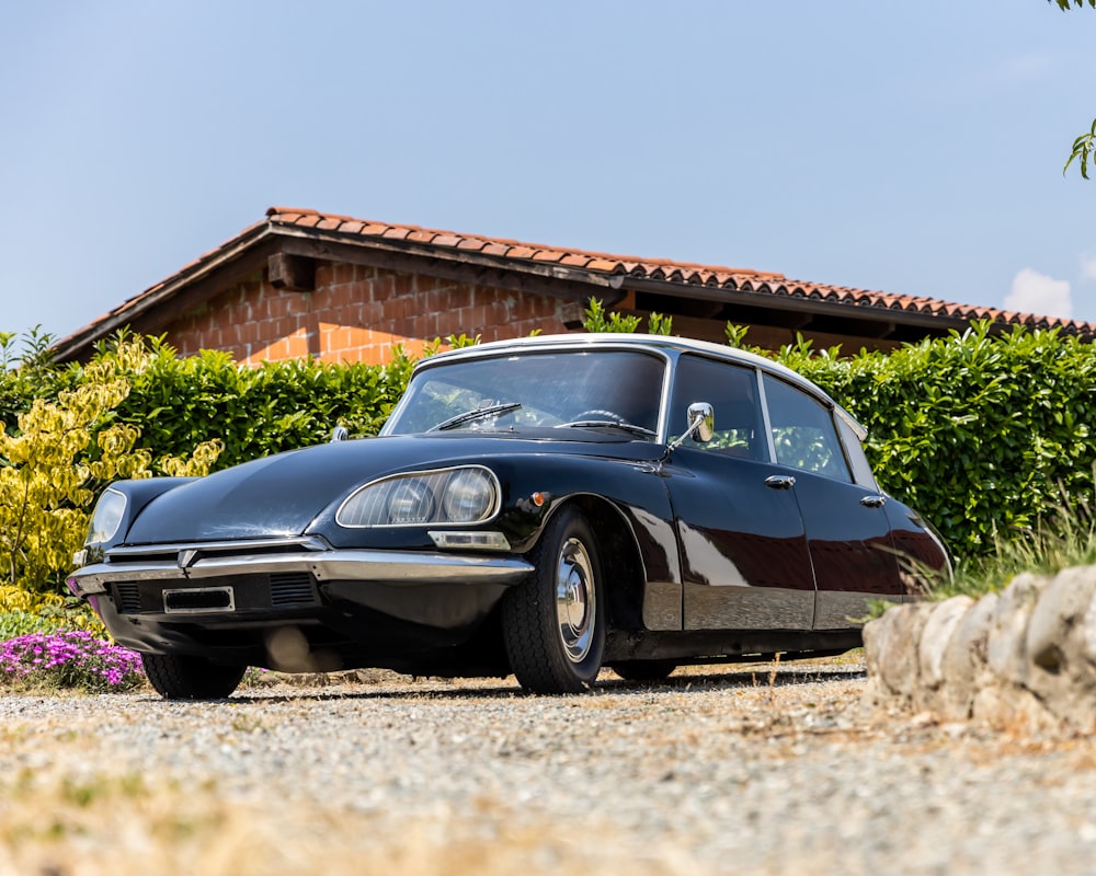 a black sports car parked in front of a house