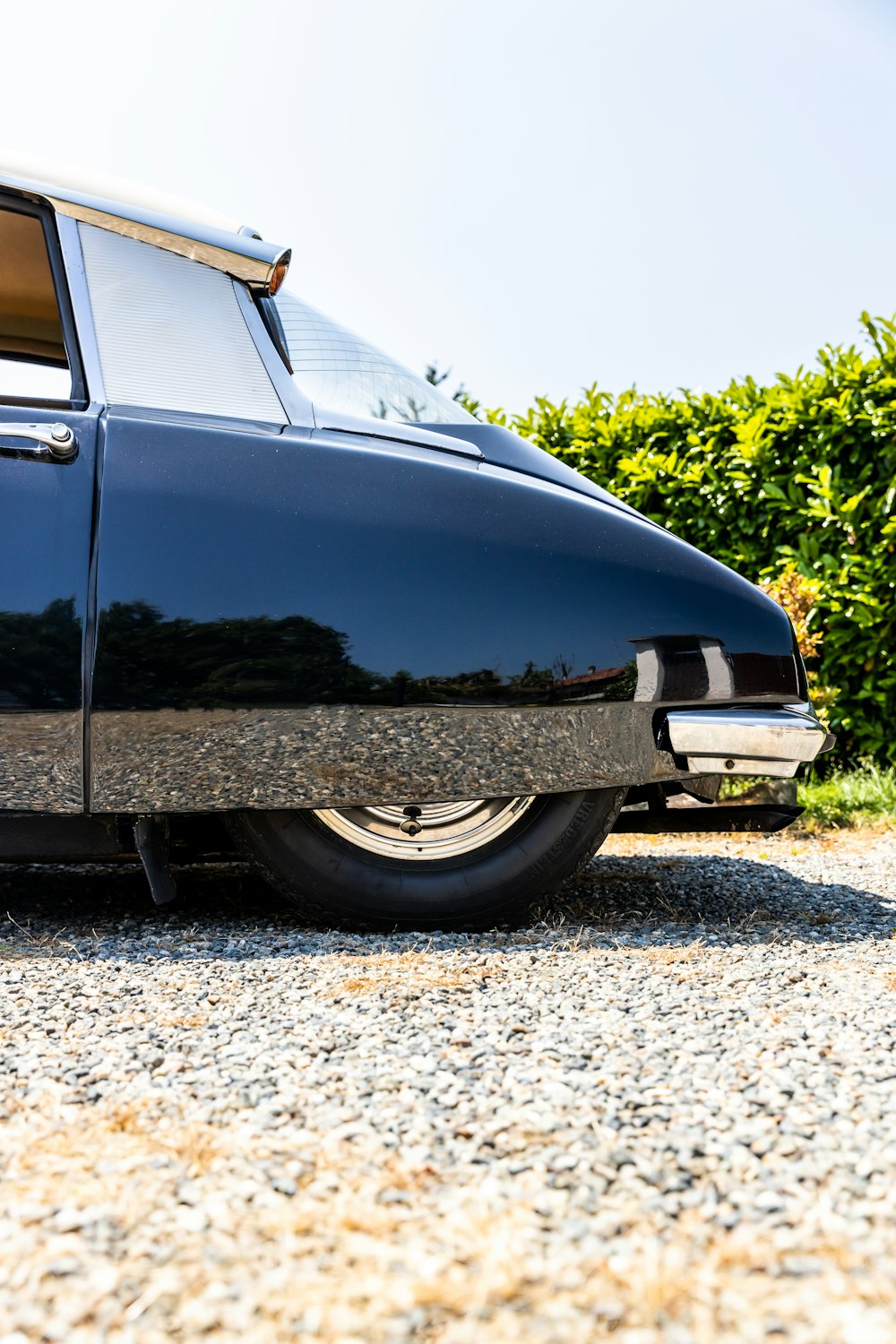 a black car parked on a gravel road