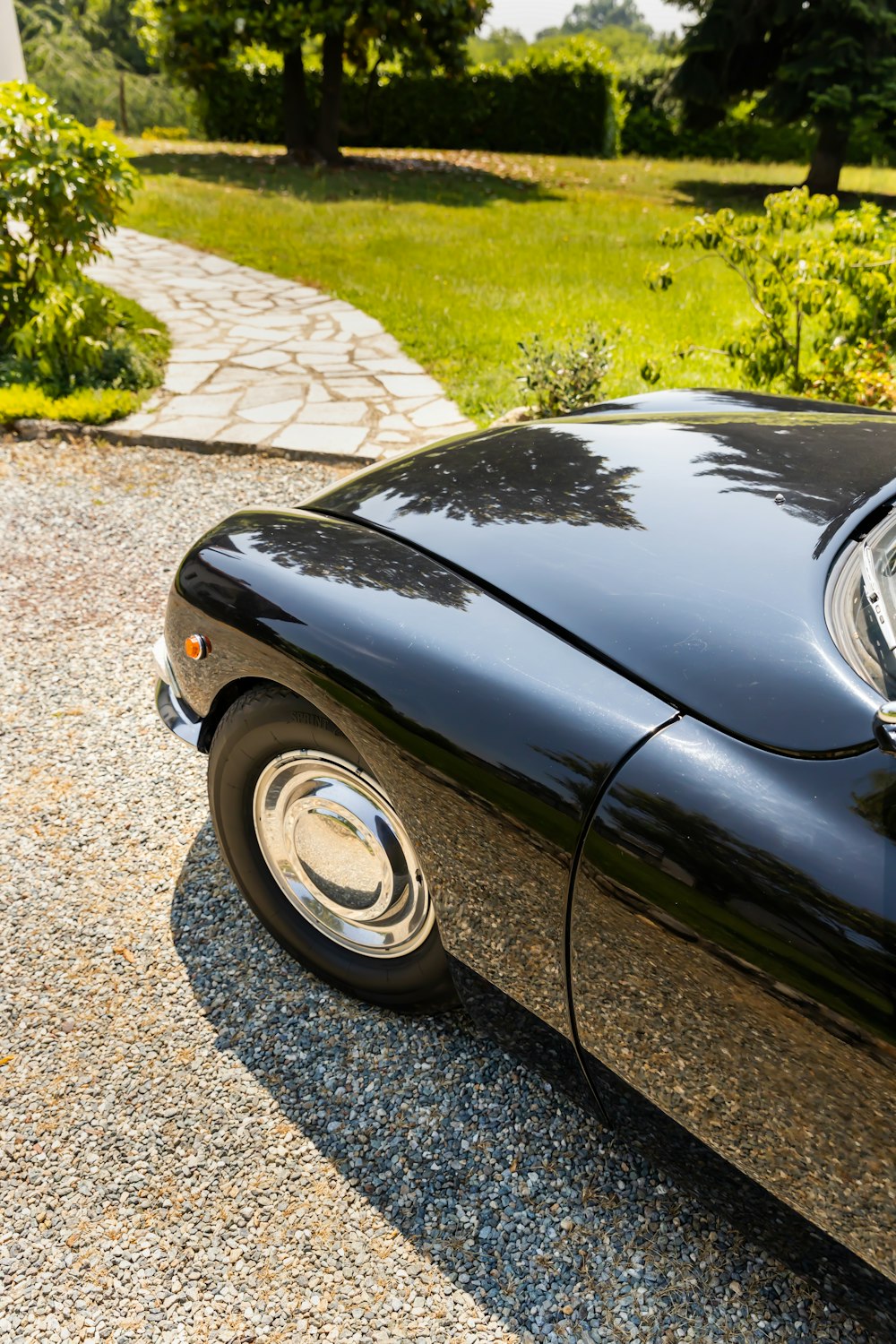 a black sports car parked on a gravel road