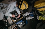 two people in hard hats working on a piece of equipment