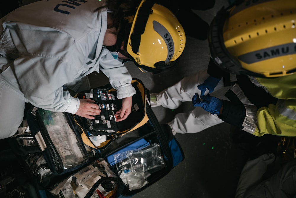 two people in hard hats working on a piece of equipment