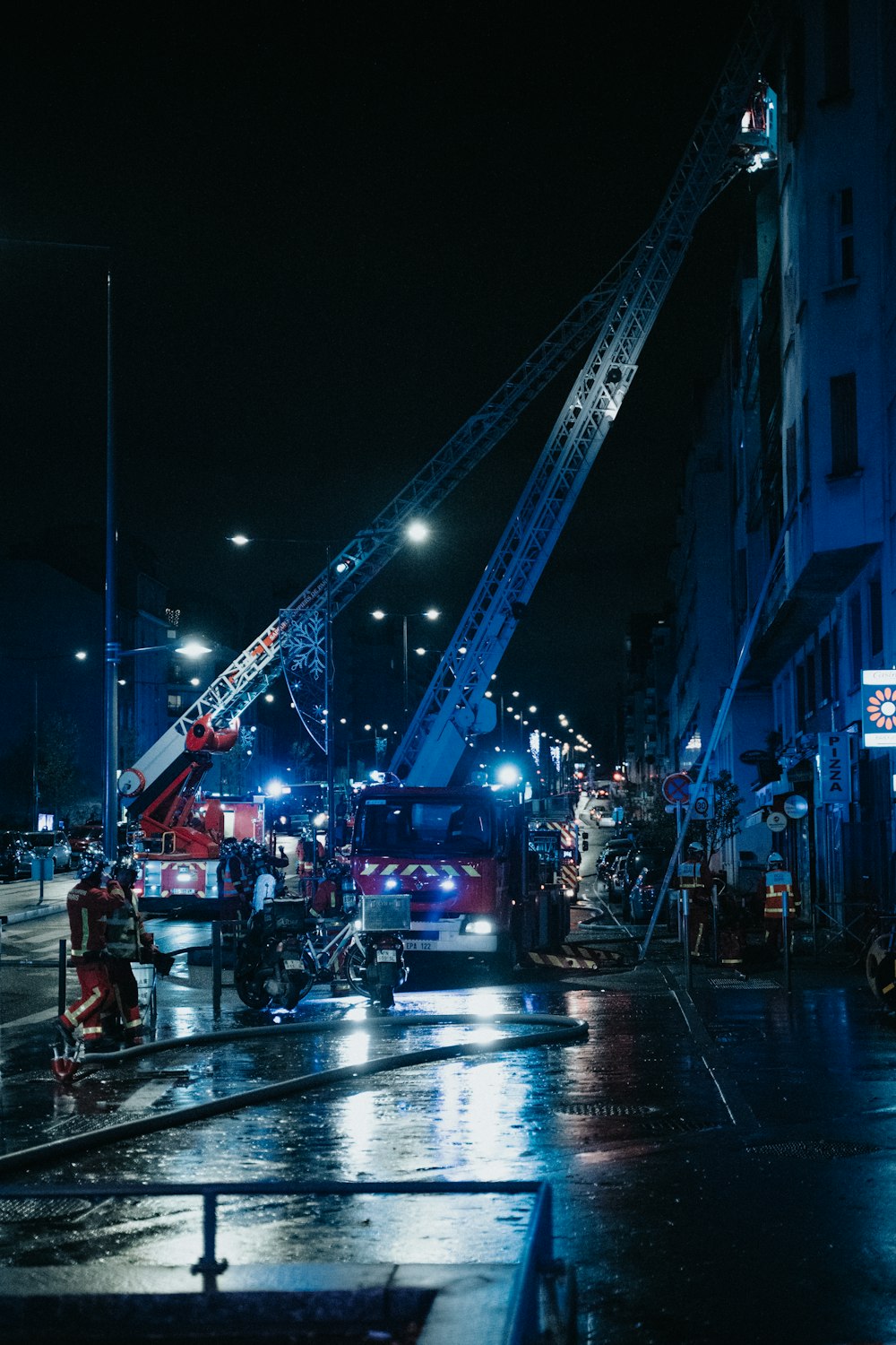 ein Feuerwehrauto und ein Feuerwehrauto auf einer Stadtstraße bei Nacht