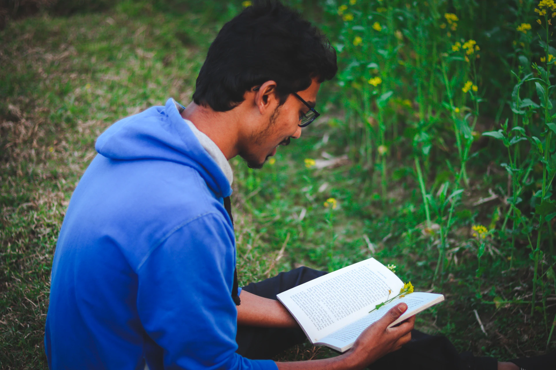 a man sitting on the ground reading a book