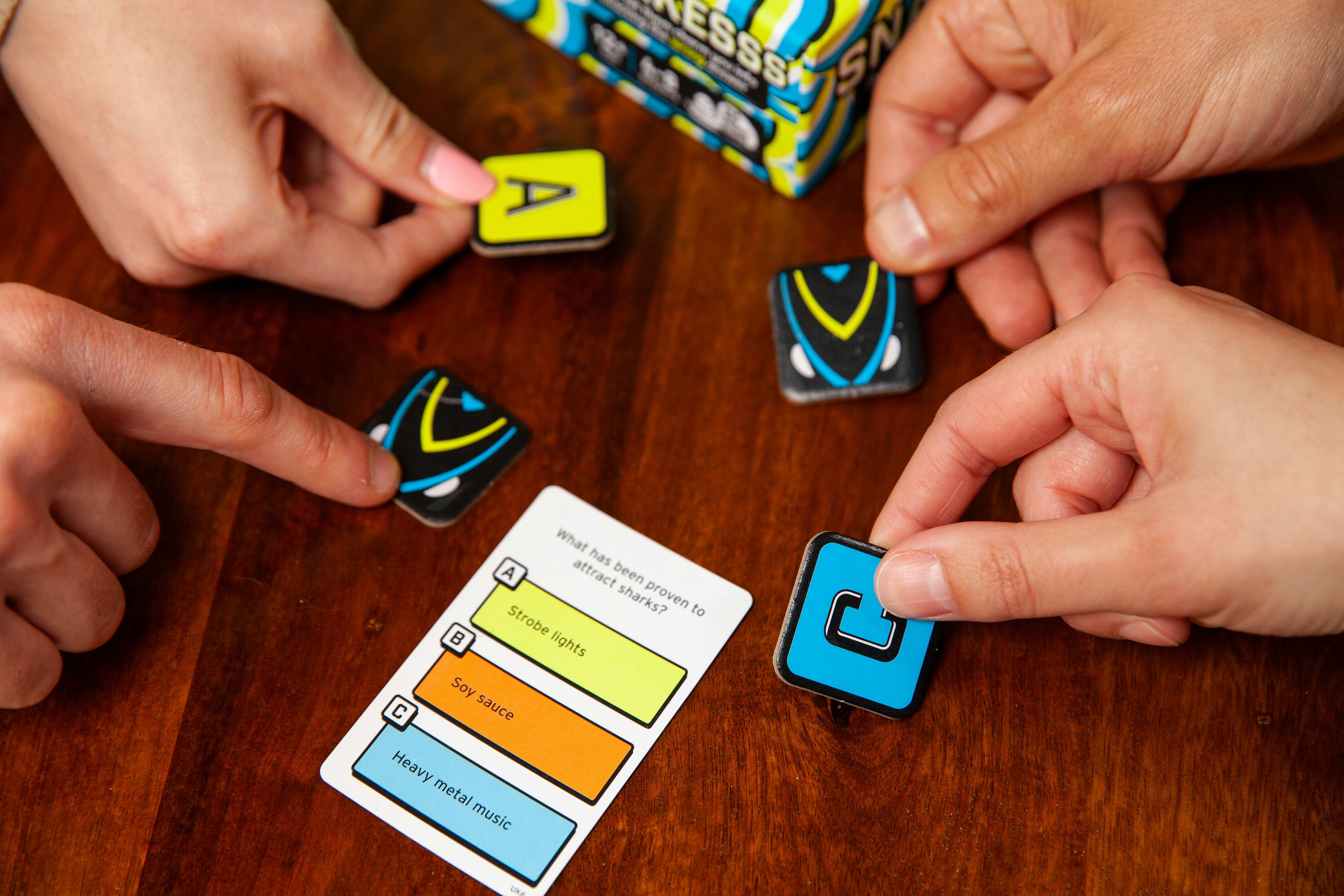 Hands reveal their answers in the game Snakesss.