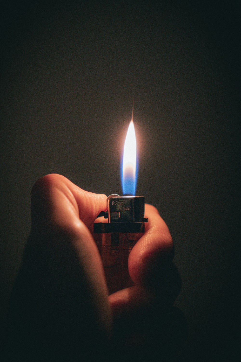 a person holding a lighter in their hand