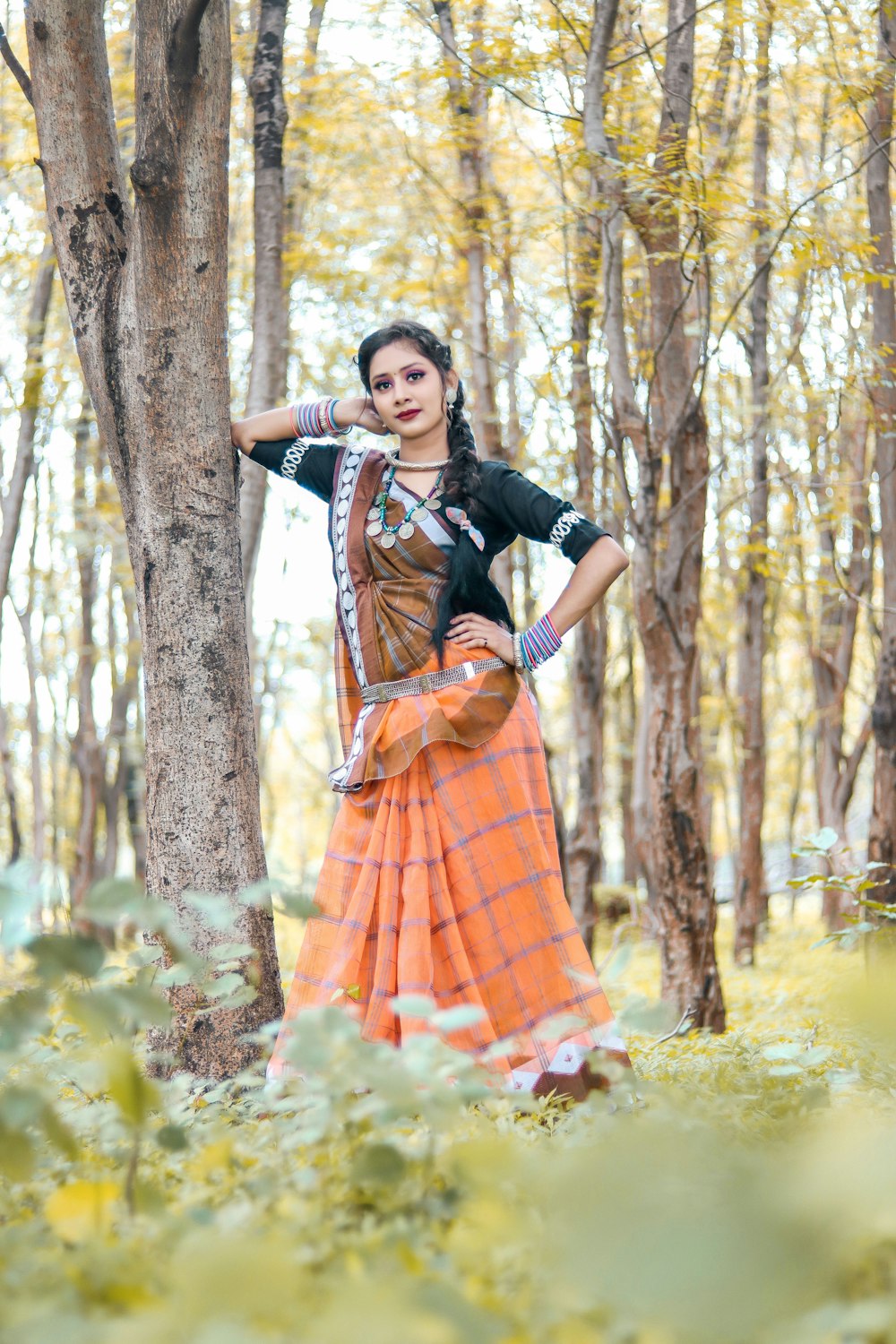 a woman standing in the woods with her hands on her hips