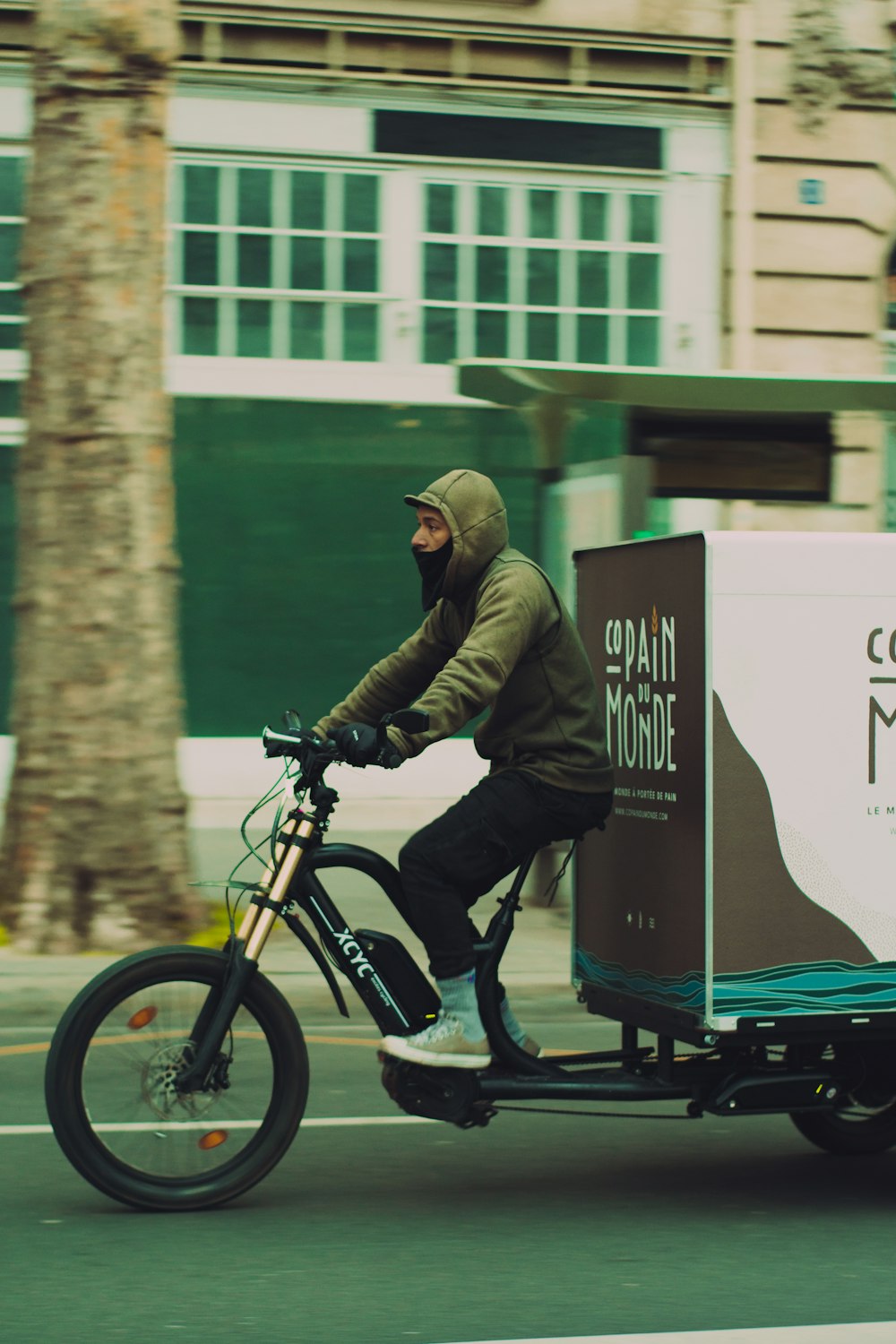 a man riding a bike with a box on the back of it