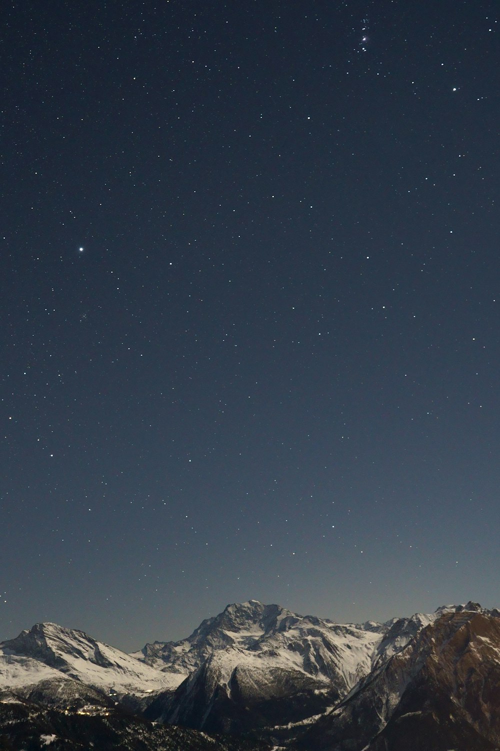 Il cielo notturno sopra una catena montuosa con le stelle nel cielo