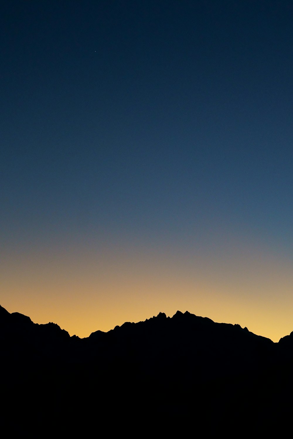 a plane flying in the sky over a mountain range