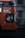 An orange double-decker bus in motion with destination details like Blackbird Leys, Cowley Road, city centre, and rail station displayed on its side. The focal point is the bus driver visible through the large window. The background appears blurred, emphasizing the bus's movement.