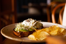 a white plate topped with a sandwich and chips