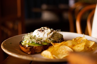 a white plate topped with a sandwich and chips