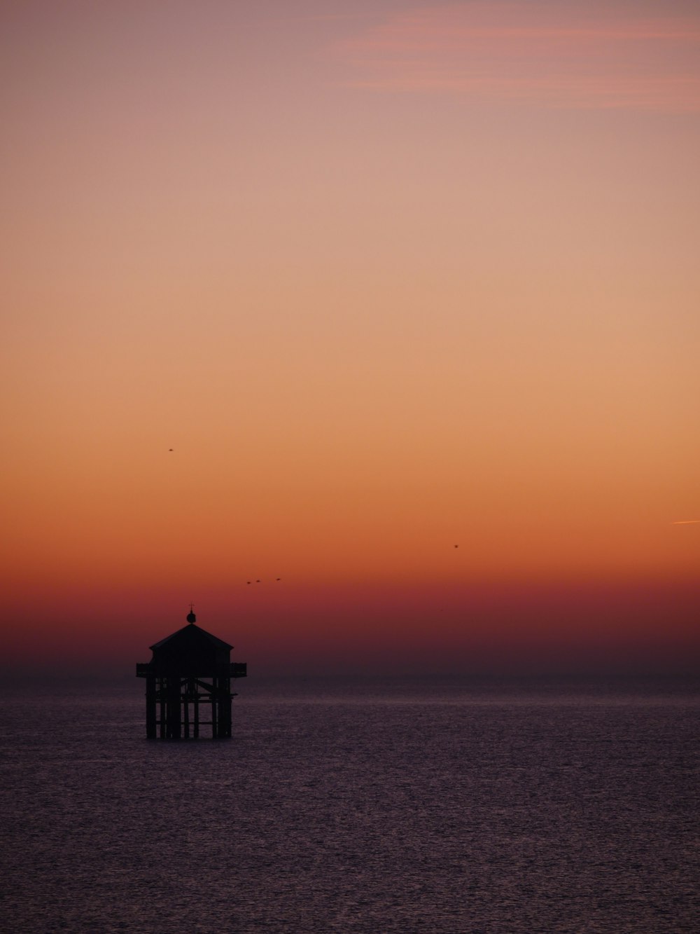 Un mirador en medio del océano al atardecer