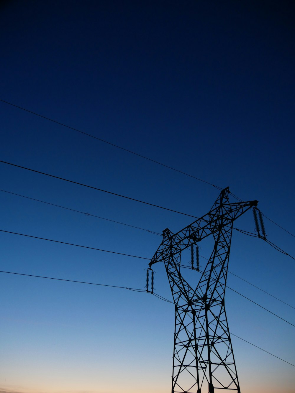 a high voltage power line with a blue sky in the background