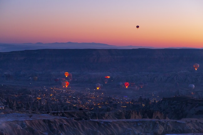 Ultra HD image of hot air balloons glowing at sunrise above the Atlas Mountains.