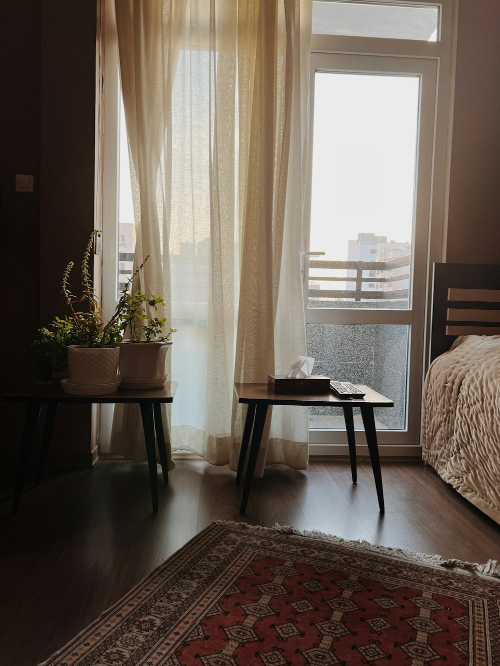 a bedroom with a bed and a rug in front of a window