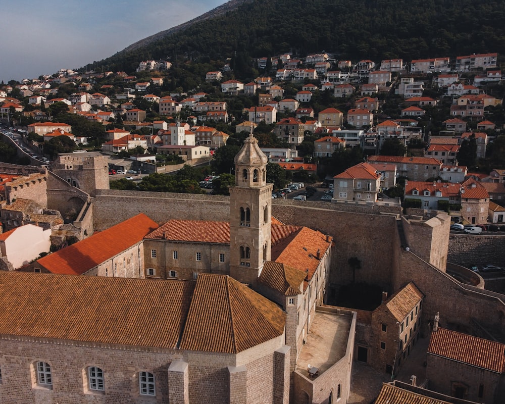 an aerial view of a city with a steeple in the background