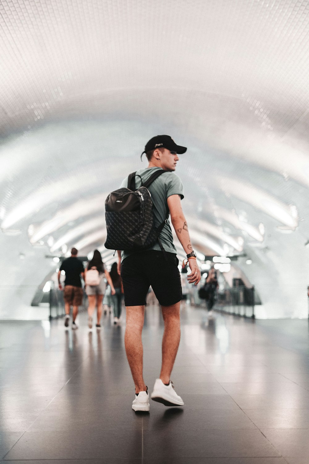 a man with a backpack walking through a subway station