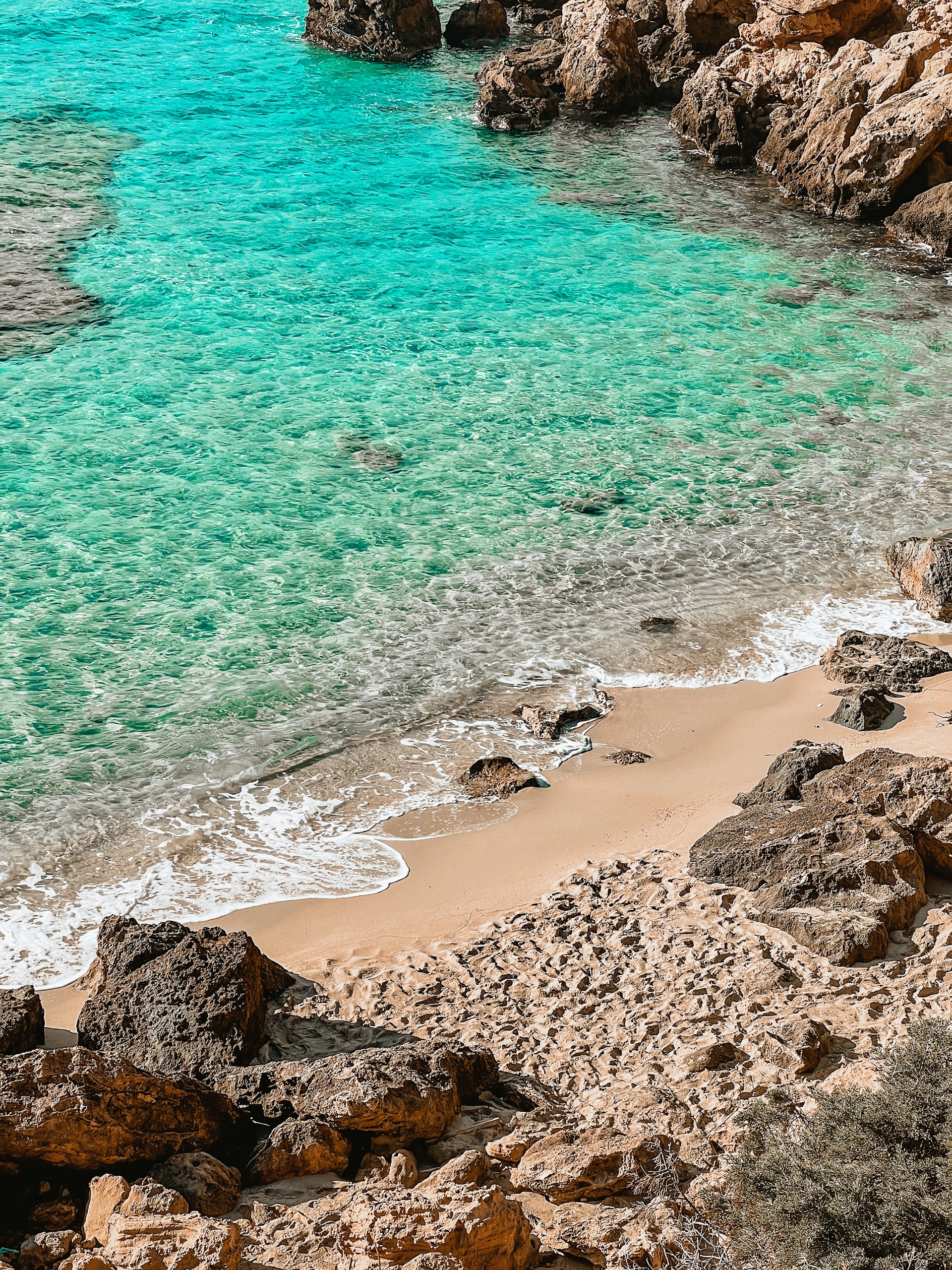 a sandy beach next to a body of water
