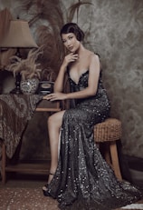 a woman in a black dress sitting at a table