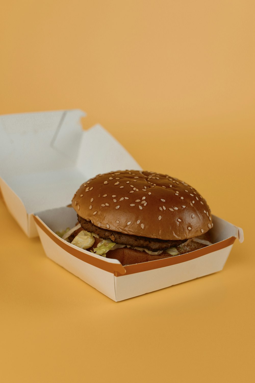 a hamburger in a box on a yellow background