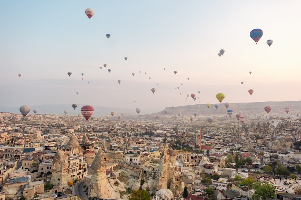 a bunch of hot air balloons flying over a city