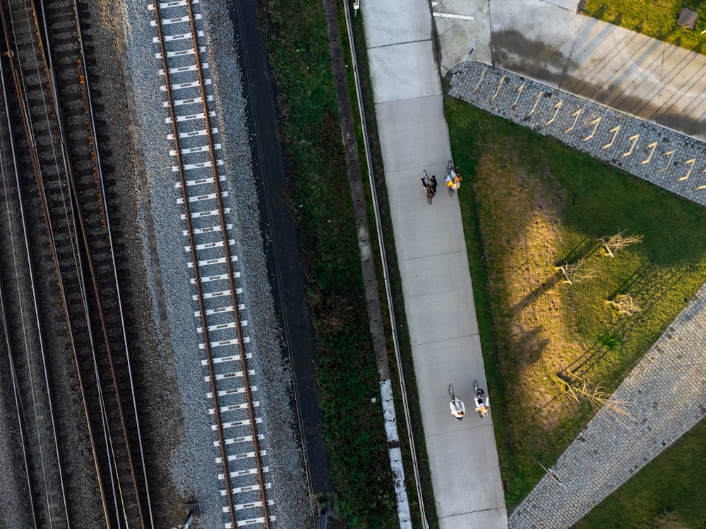 an aerial view of a train track next to a grassy area