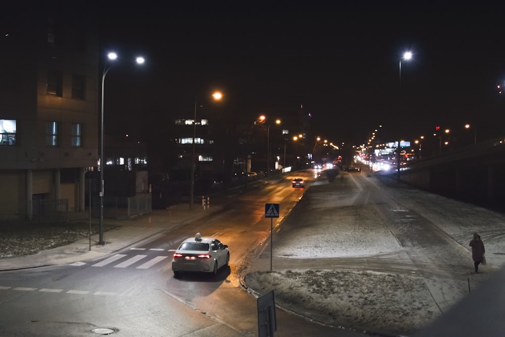 a car driving down a street at night