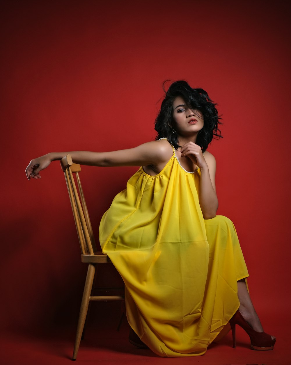 a woman in a yellow dress sitting on a chair