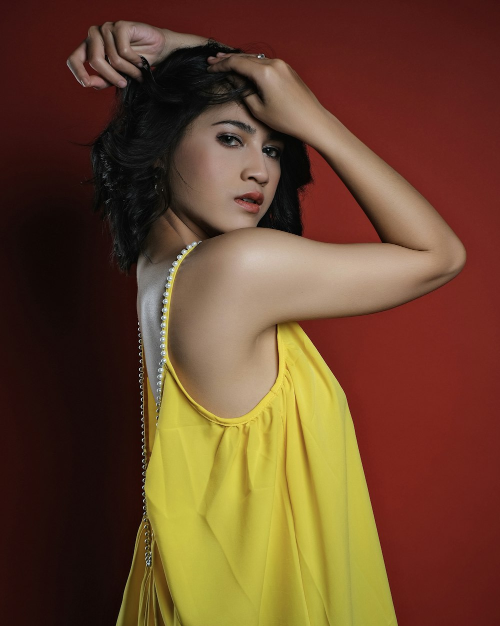 a woman in a yellow dress posing for a picture