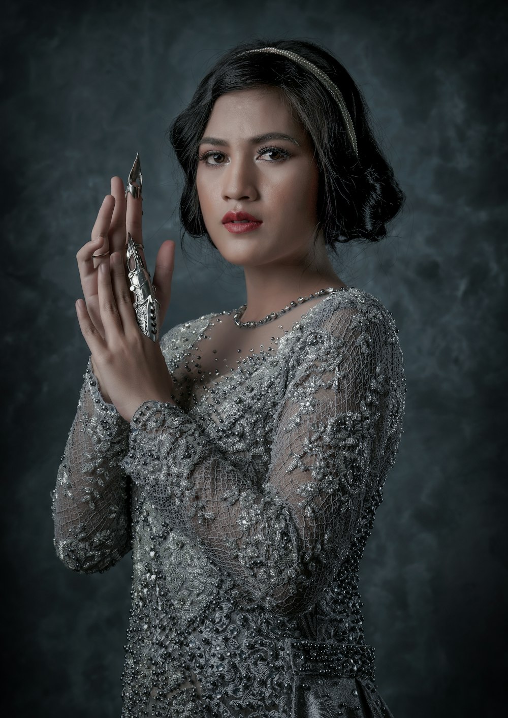 a woman in a silver dress holding a cell phone