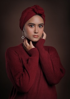 a woman wearing a red sweater and a turban