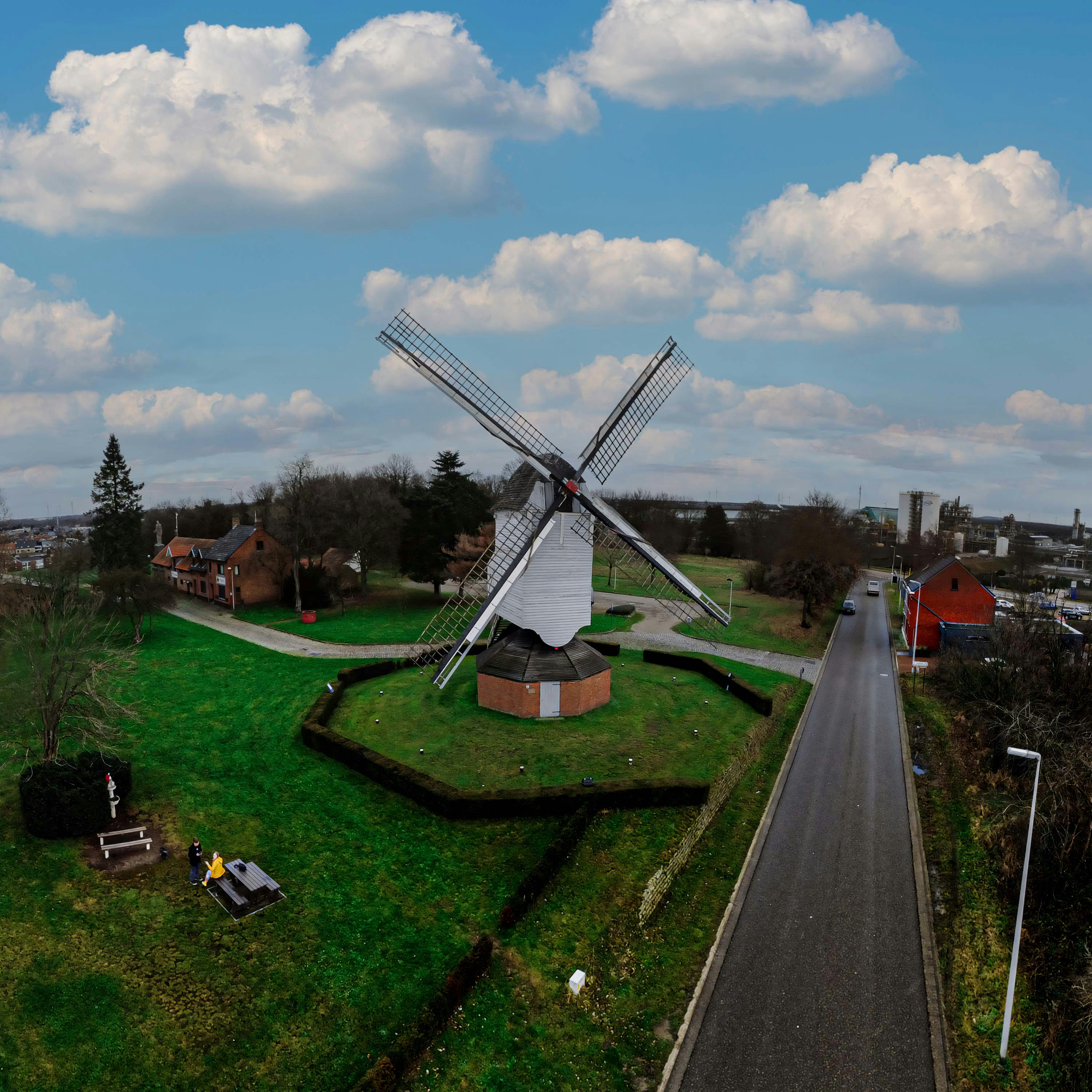 a windmill sitting on top of a lush green field