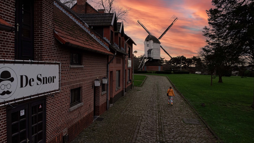 a brick building with a windmill in the background