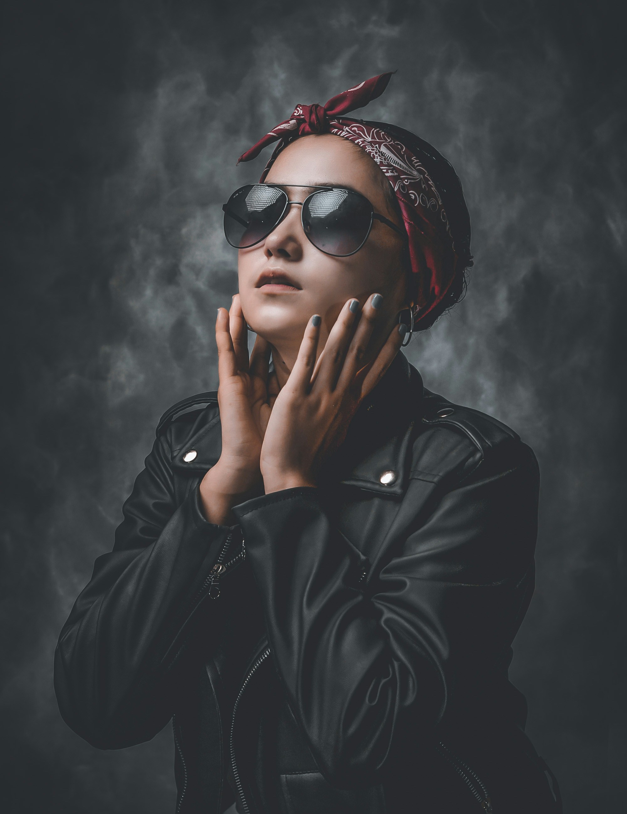 Une femme vêtue d’une veste en cuir noir et de lunettes de soleil