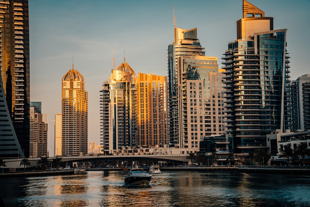 a boat traveling down a river next to tall buildings