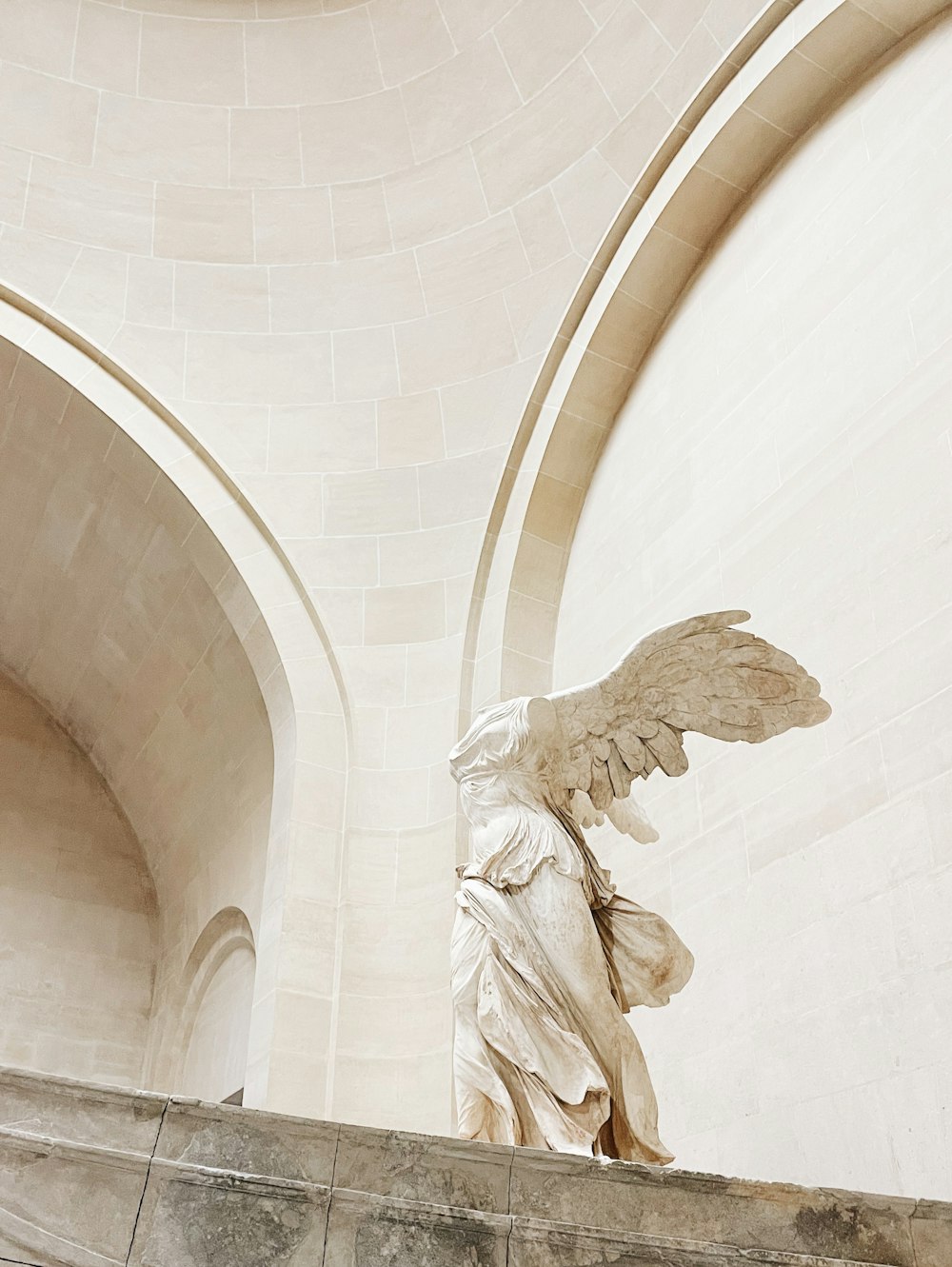 a statue of an angel on a ledge of a building