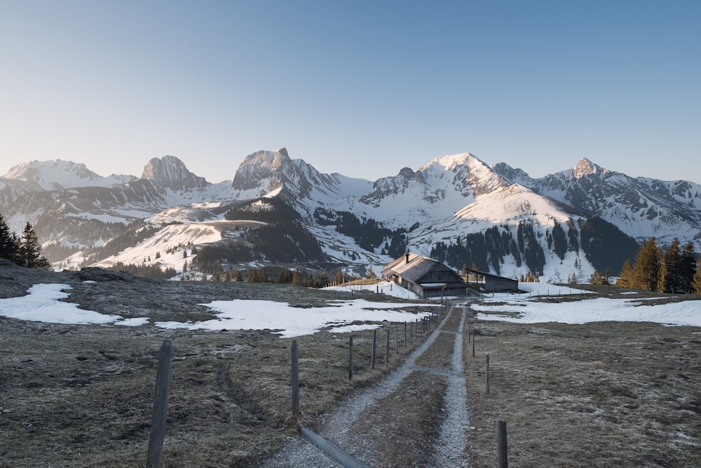 a dirt road in front of a mountain range