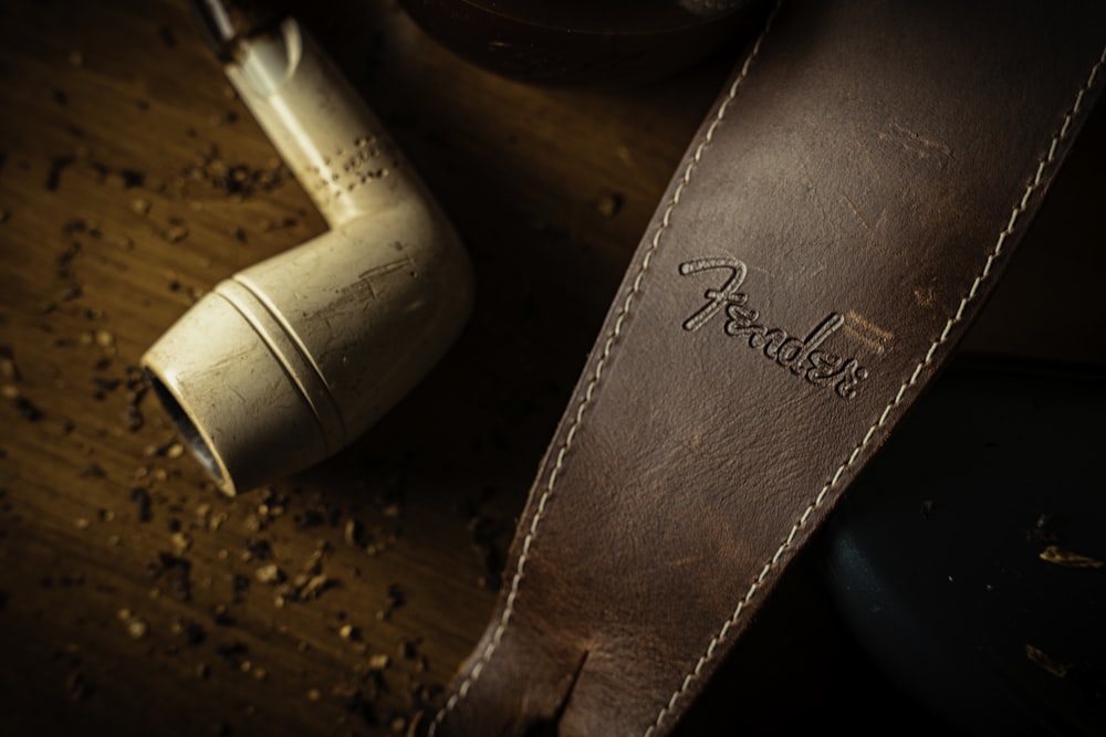 a brown leather pipe case sitting on top of a wooden table