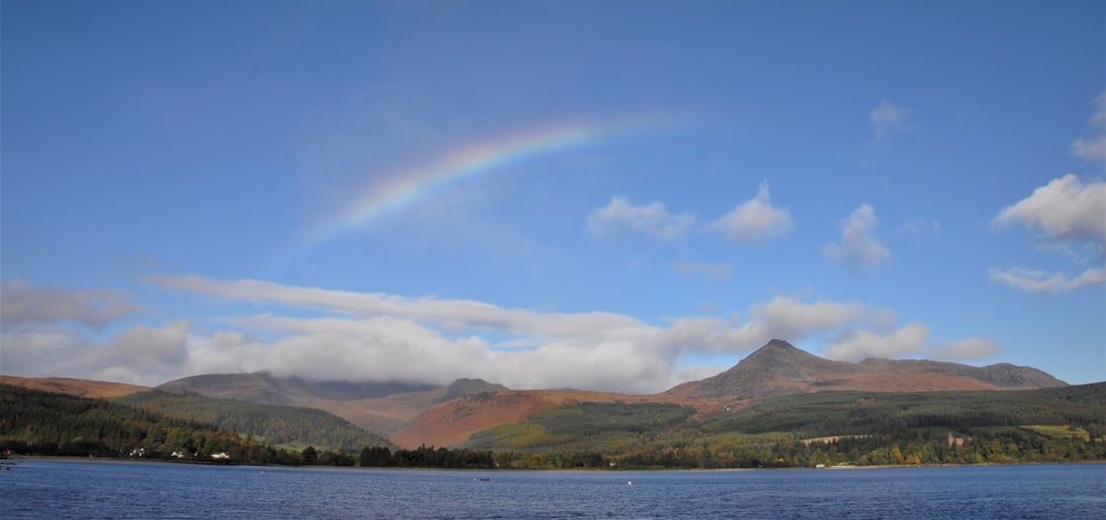 a rainbow in the sky over a lake