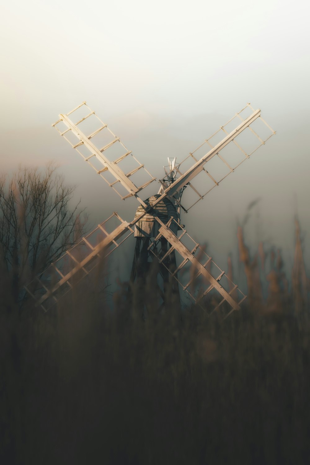 a windmill in the middle of a foggy field